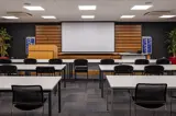 Conference room with presentation lectern, projector screen and classroom seating