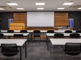 Conference room with presentation lectern, projector screen and classroom seating