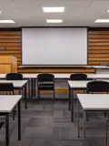 Conference room with presentation lectern, projector screen and classroom seating