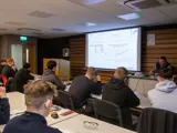 Engineering apprentices attending classroom lesson with projected presentation